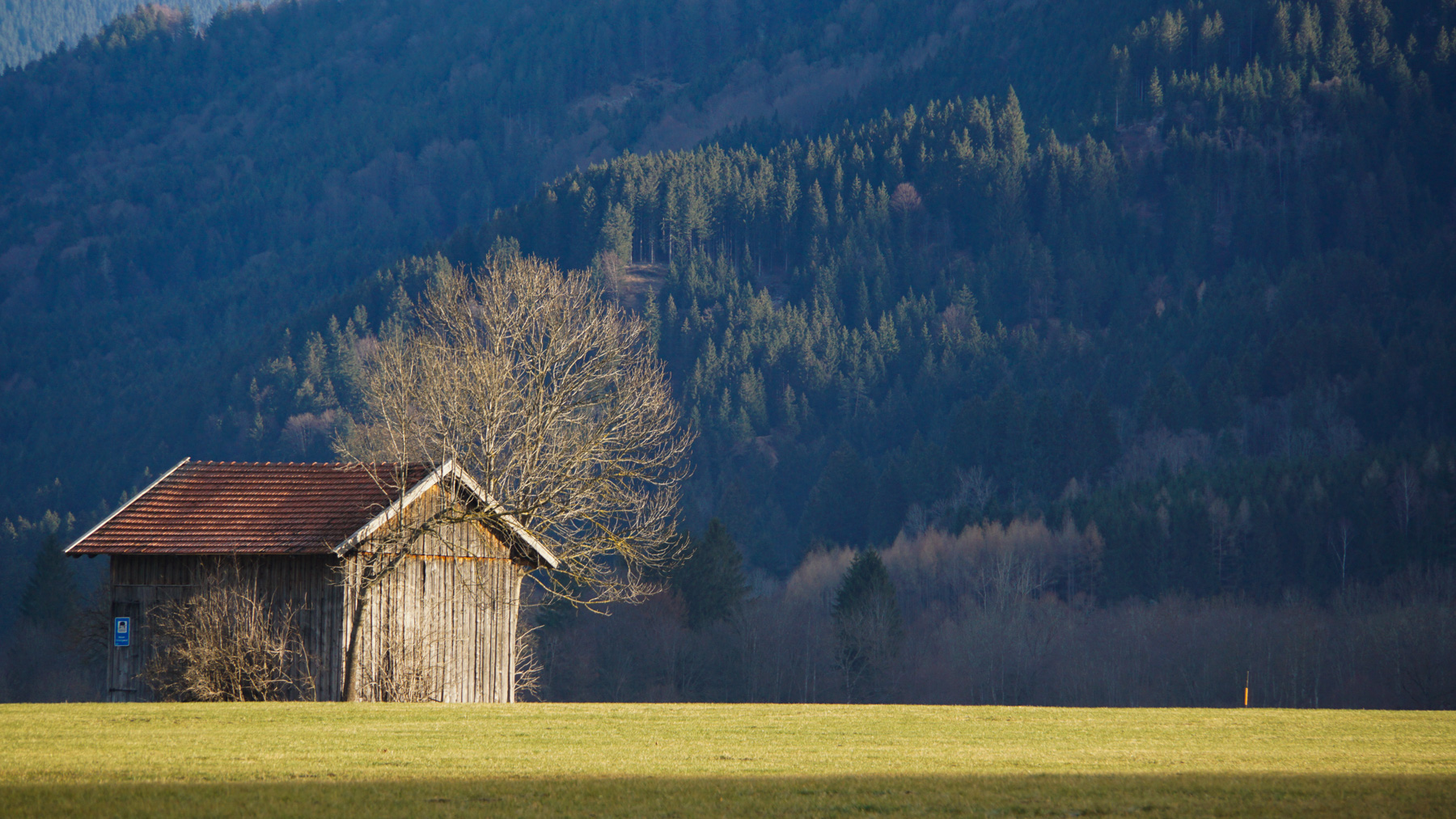 A lone farmhouse against the Bavarian mountains