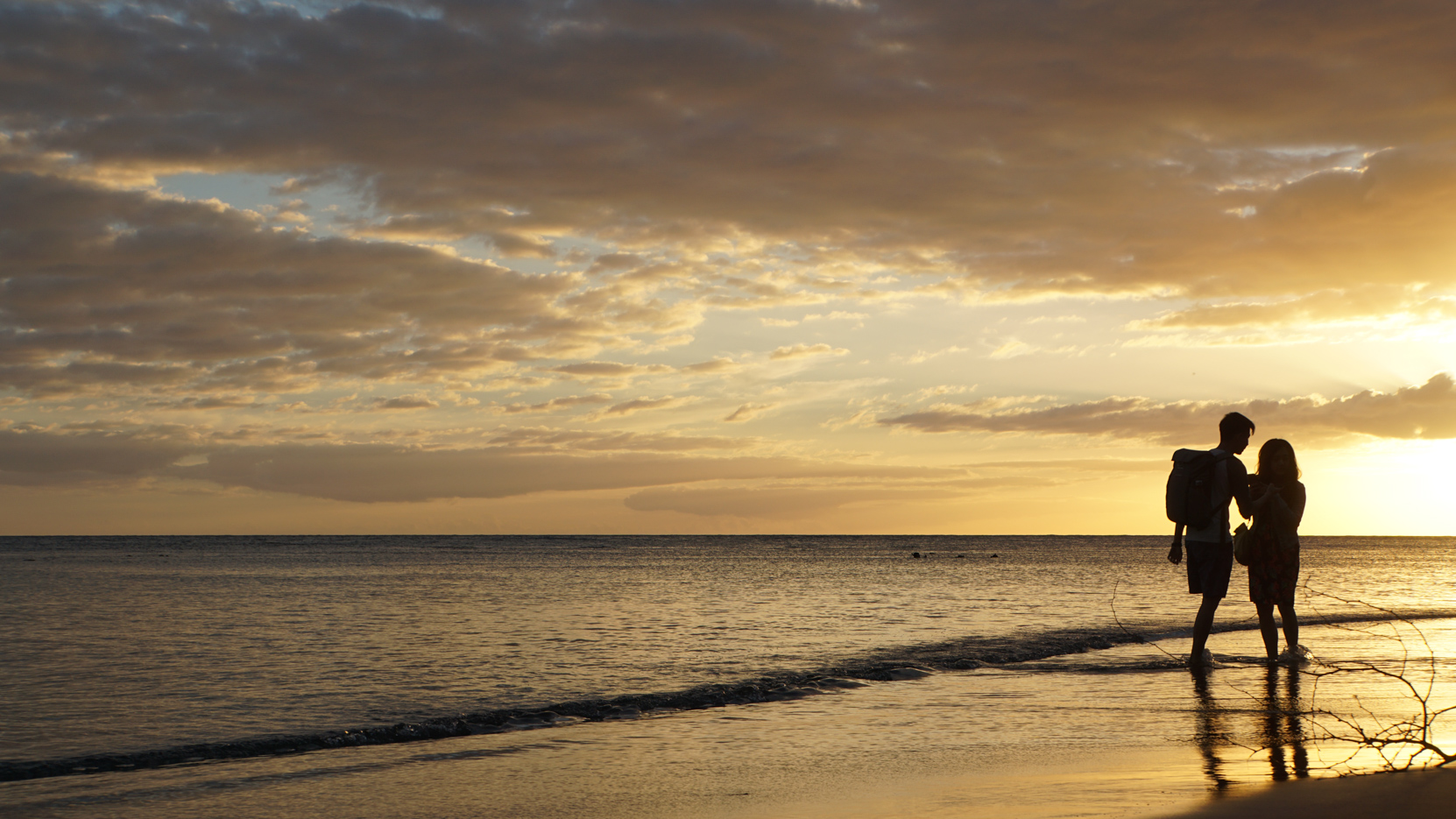 A couple on the beach at sunset