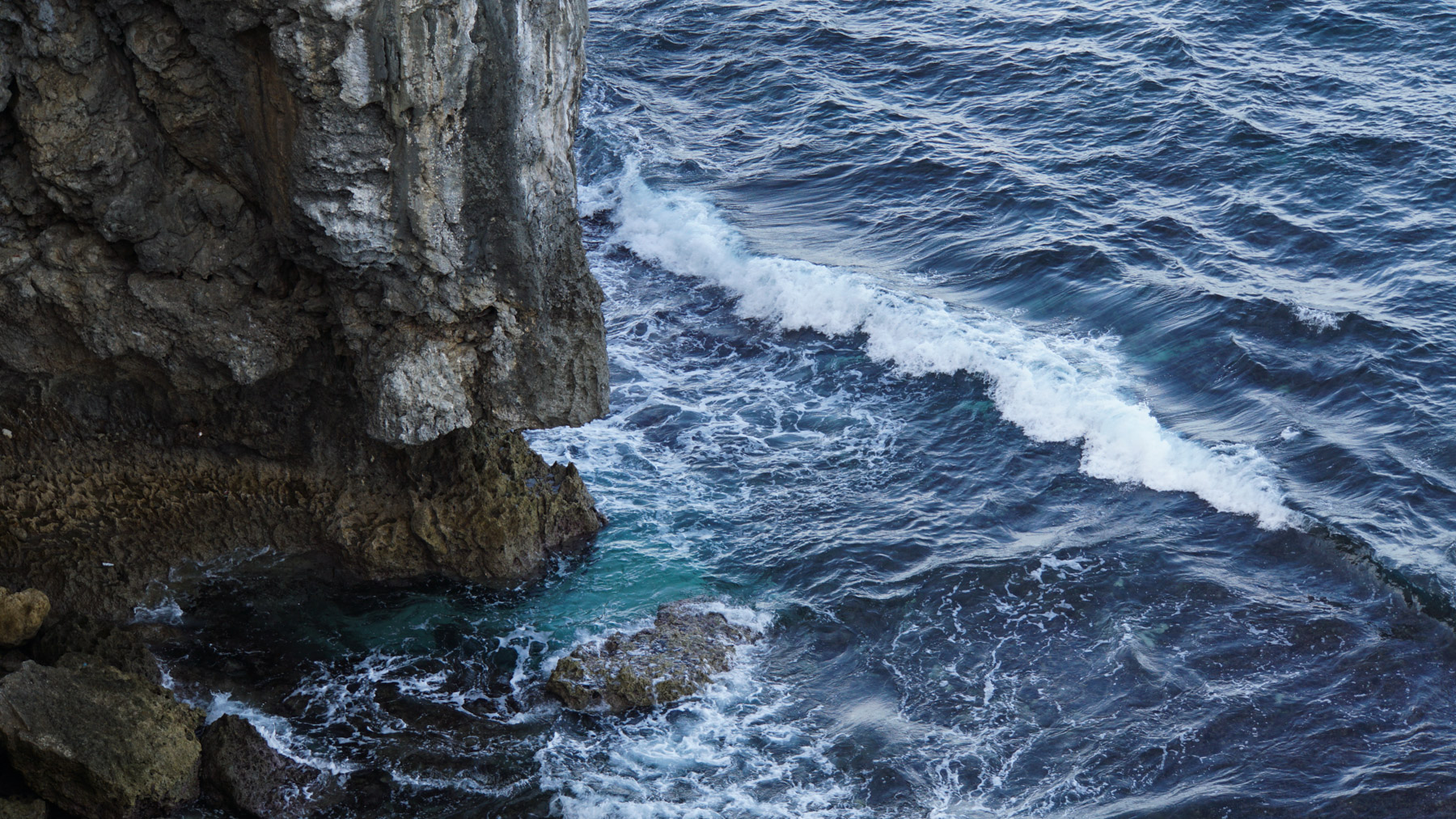 The bottom of some cliffs with waves washing over rocks